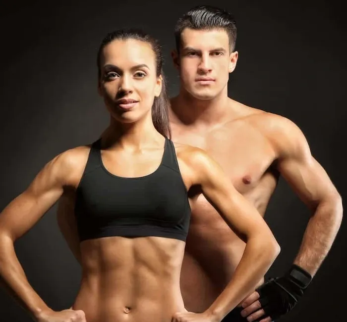 Fit man and woman in workout clothes against a dark background