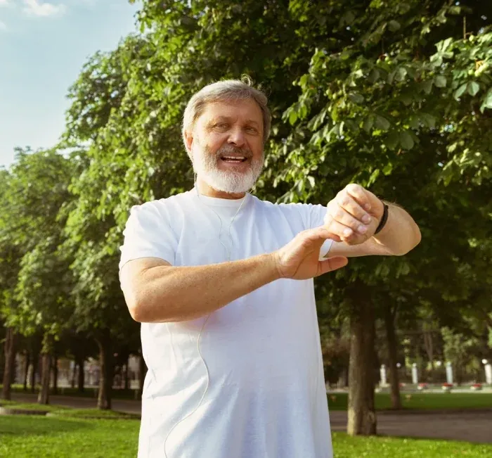 Older man in a park checking his fitness watch