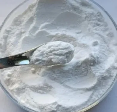 Fine white probiotic powder in a glass dish with a metal scoop